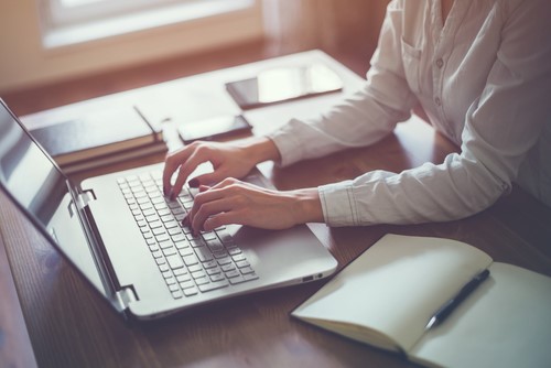woman typing on laptop nQueue